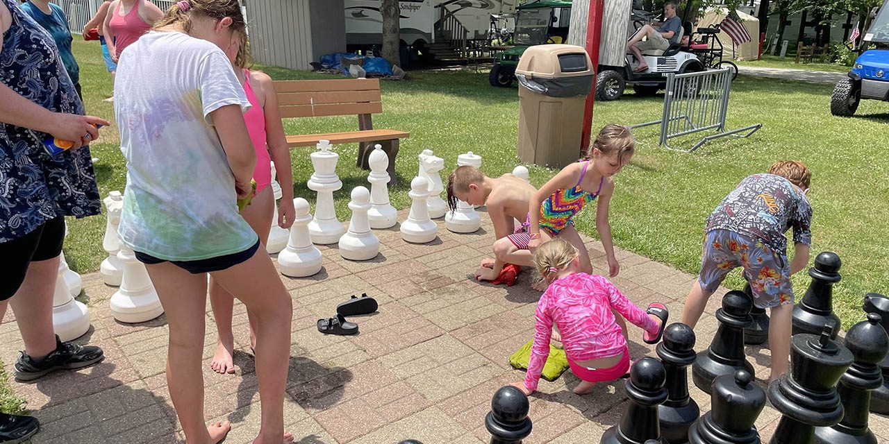 Family enjoying camping activities together at a Michigan campground with kids playing outdoors