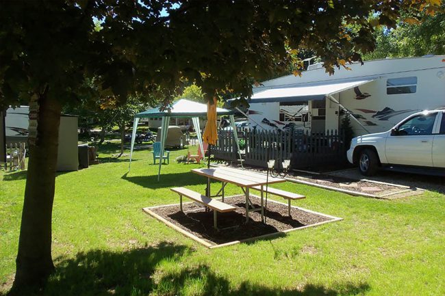 Seasonal RV camping setup near a lake in Michigan with campers enjoying summer